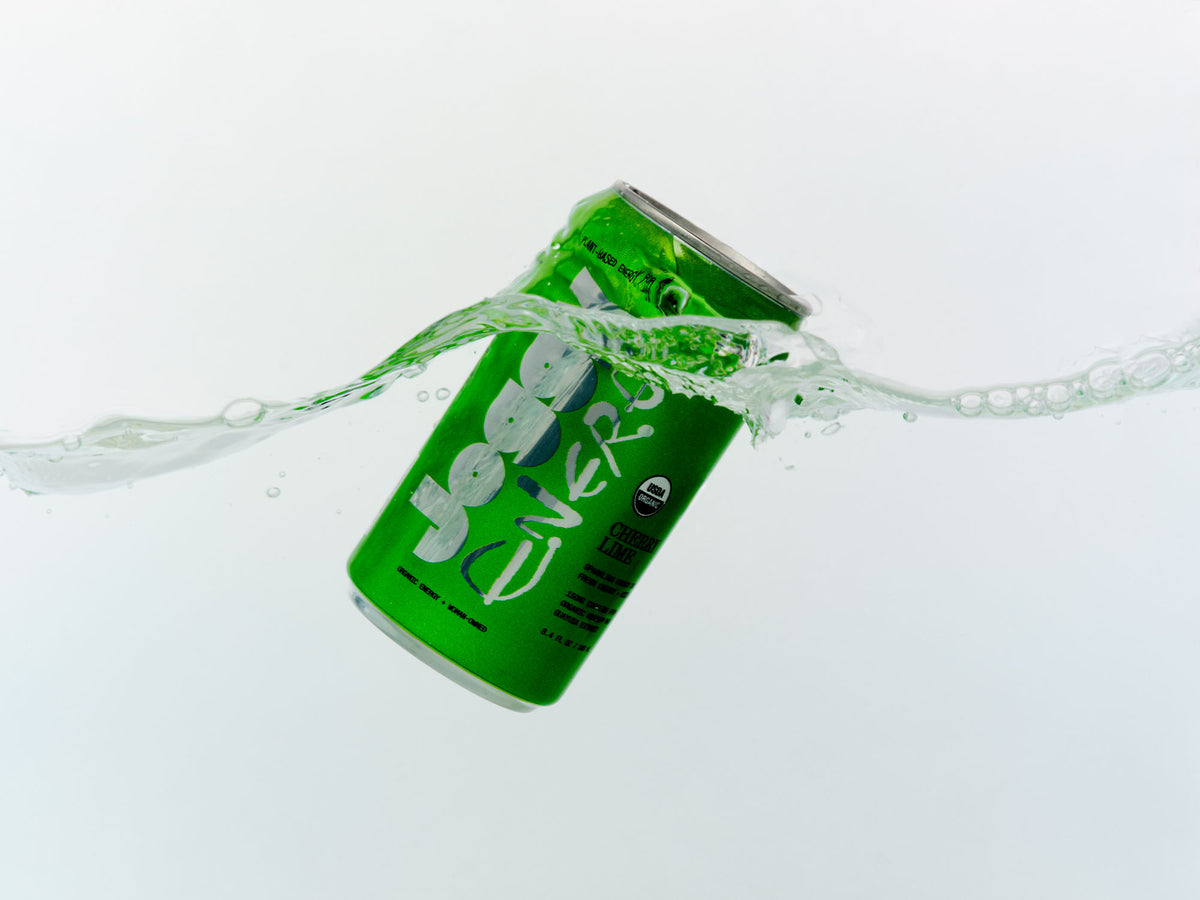 Green can of Joggy splashing into water on a white background