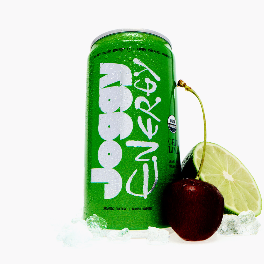 Green energy drink can with a cherry and lime wedge on a white background