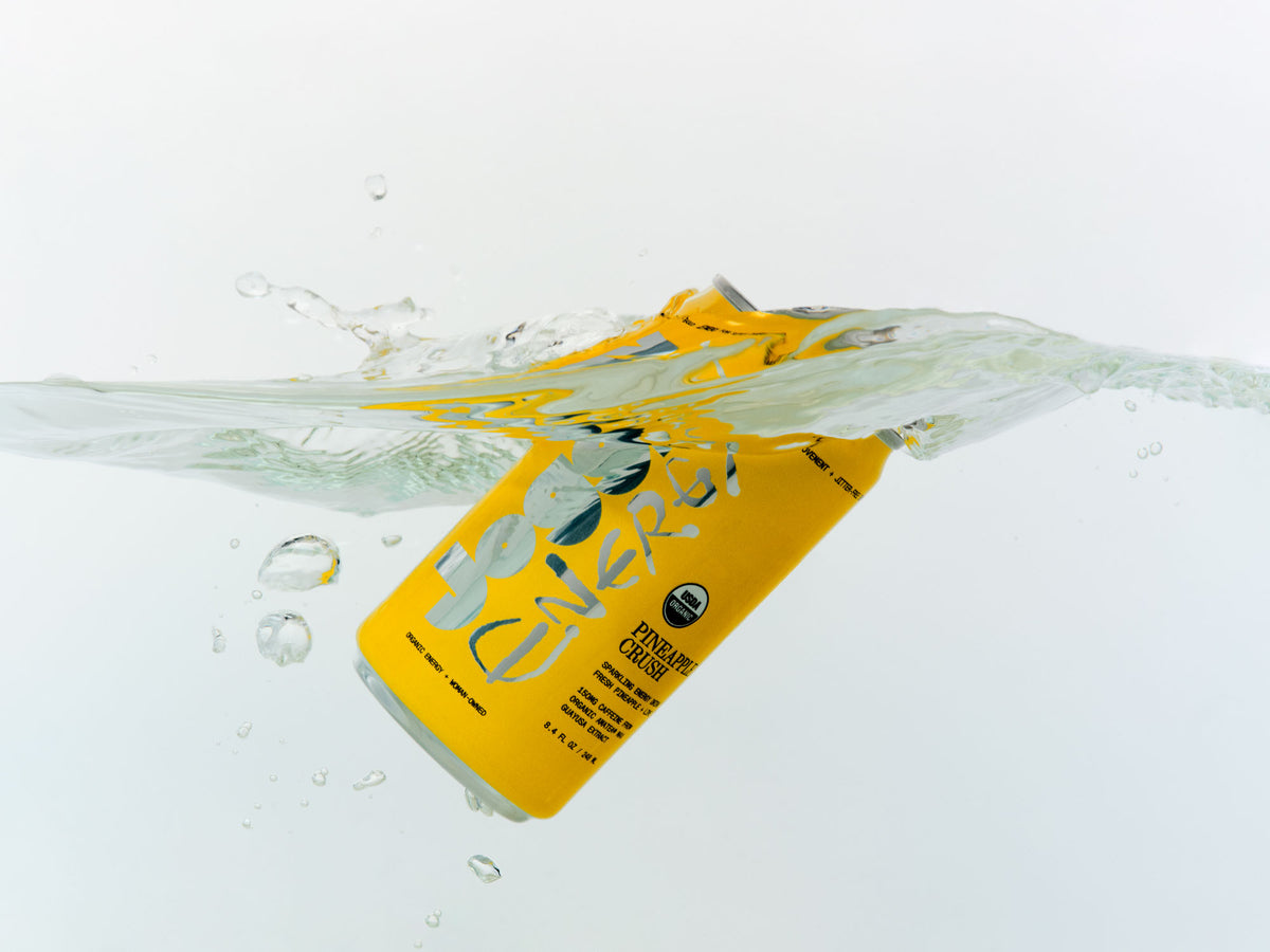 Yellow can of Joggy splashing into water on a white background