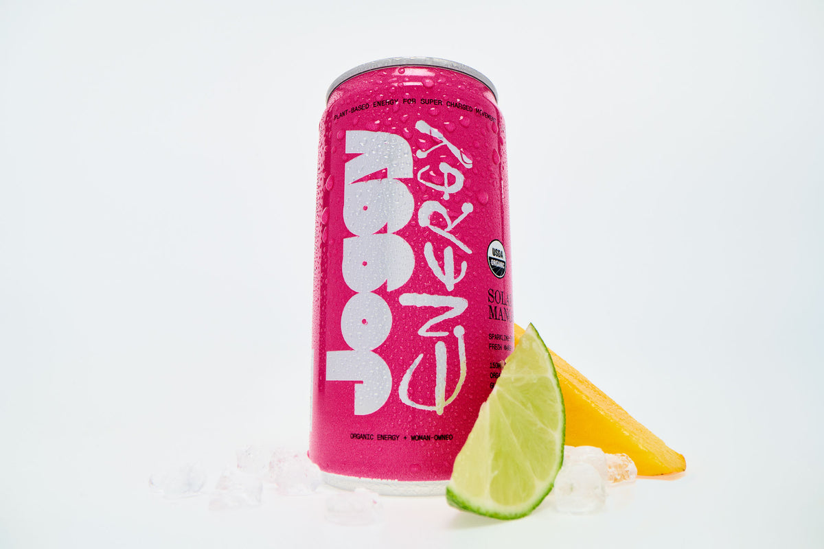 Pink energy drink can with lime and pineapple on a white background